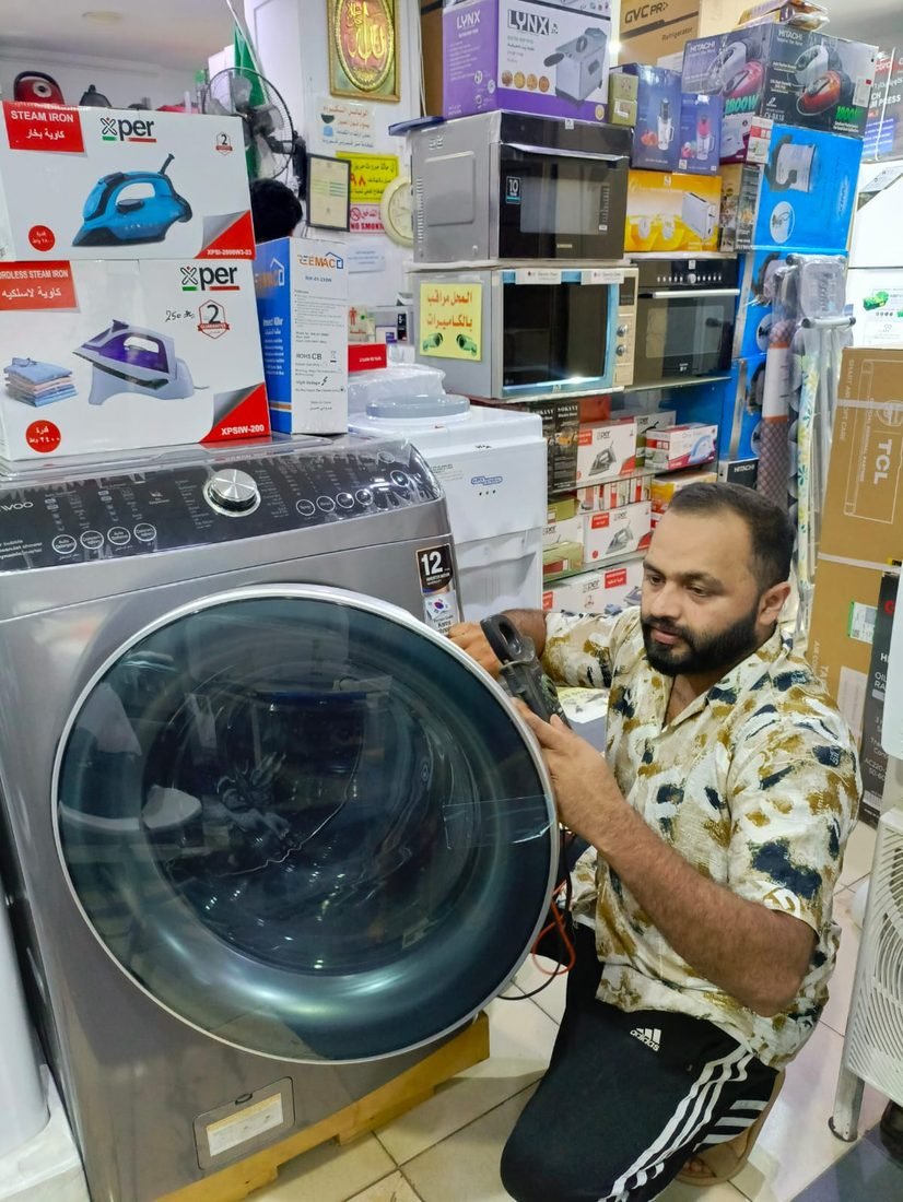 Technician testing an automatic washing machine in Jeddah